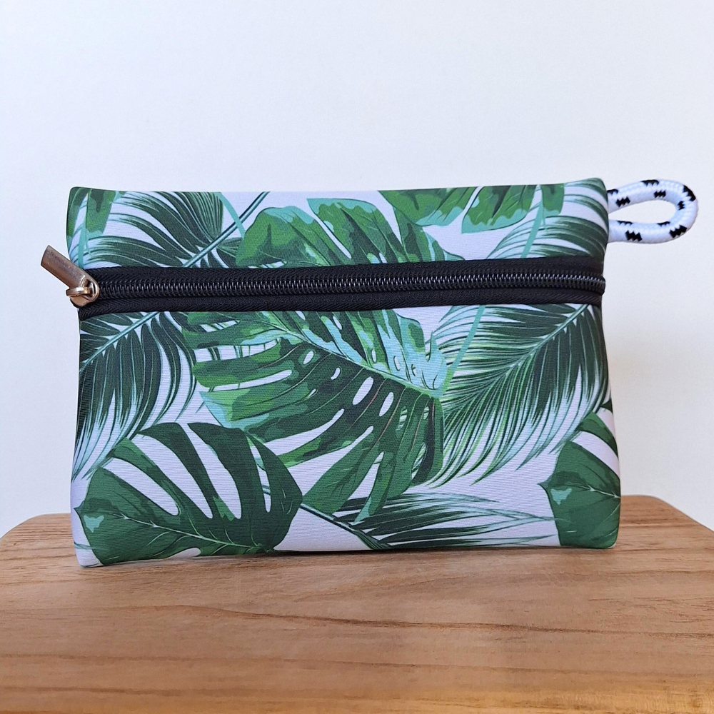 Estuche de neopreno con diseño de hojas verdes, práctico y resistente. Perfecto para cosméticos, accesorios y uso diario. Ideal para la universidad, trabajo, gimnasio o playa.