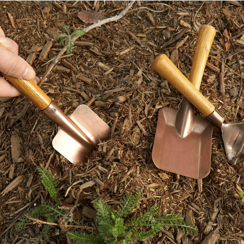 Set de herramientas de jardinería rústicas con pala, rastrillo y pala cuadrada, mango de madera y acabado en cobre, ideal para pequeños jardines y regalos.