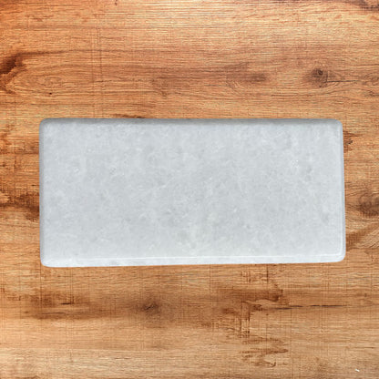 Tabla de mármol blanco rectangular de 25 x 12 cm, ideal para servir alimentos o como pieza decorativa.